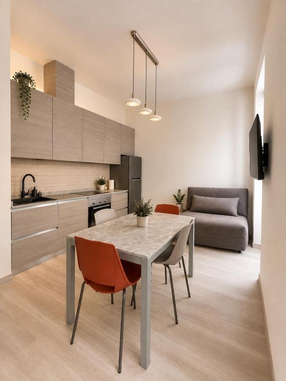 Living area with kitchen, dining table and sofa at Trieste Luxury Apartment